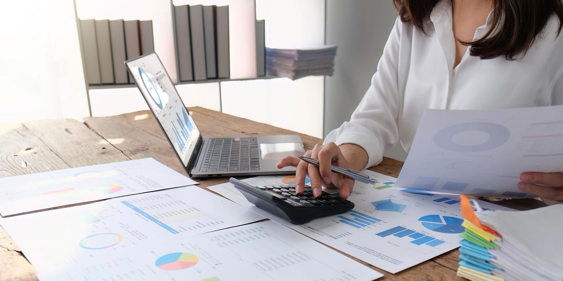 female employee working on a laptop computer in a modern office. Make an account analysis report. real estate investment information financial and tax system concepts